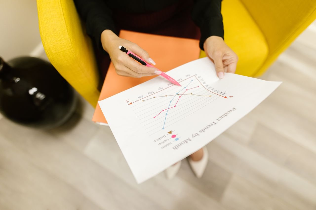 Services Woman reviewing a product trend graph analysis indoors.