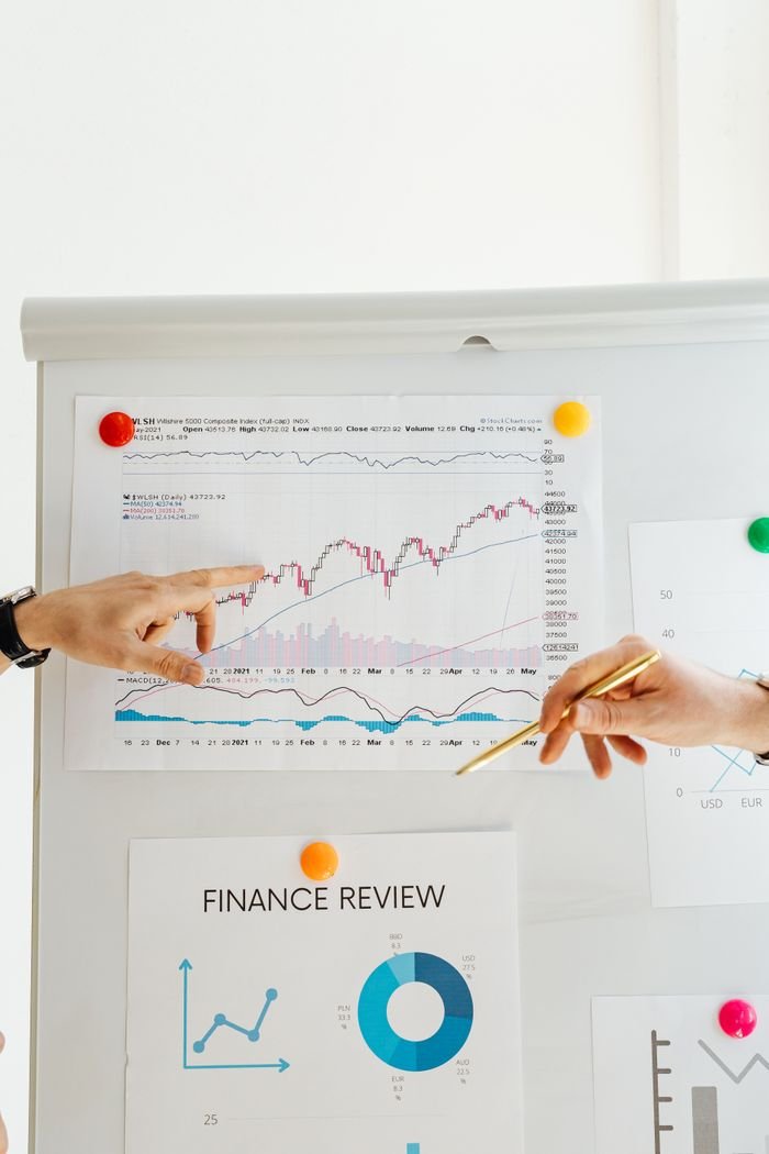 Services Hands pointing to financial charts during an office presentation.