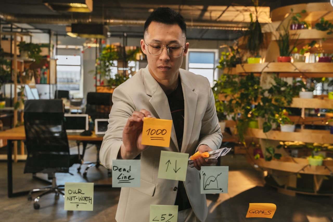 Services Focused businessman using sticky notes for planning in a green office.