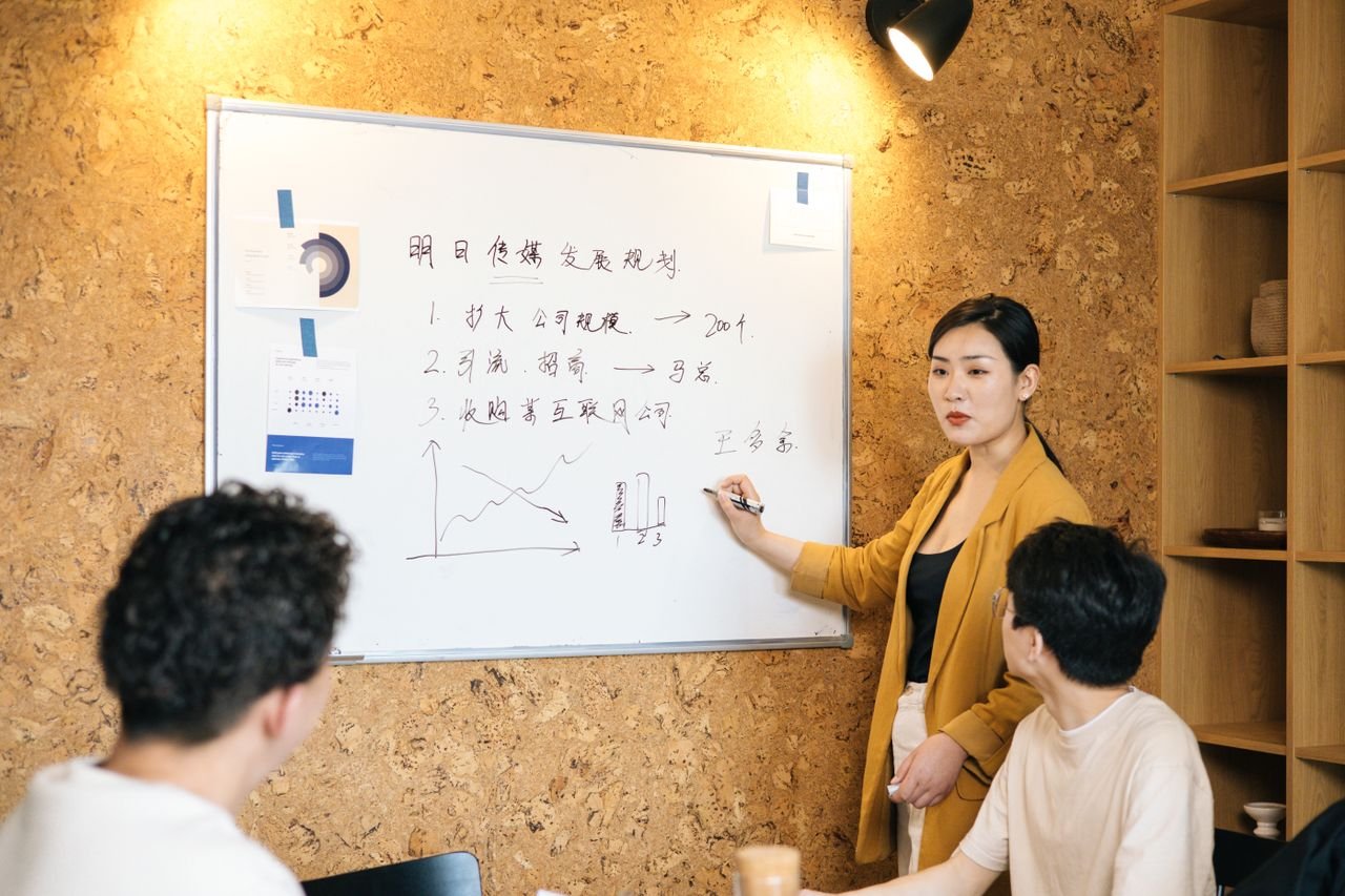Services Business team brainstorms strategies on a whiteboard during a meeting.